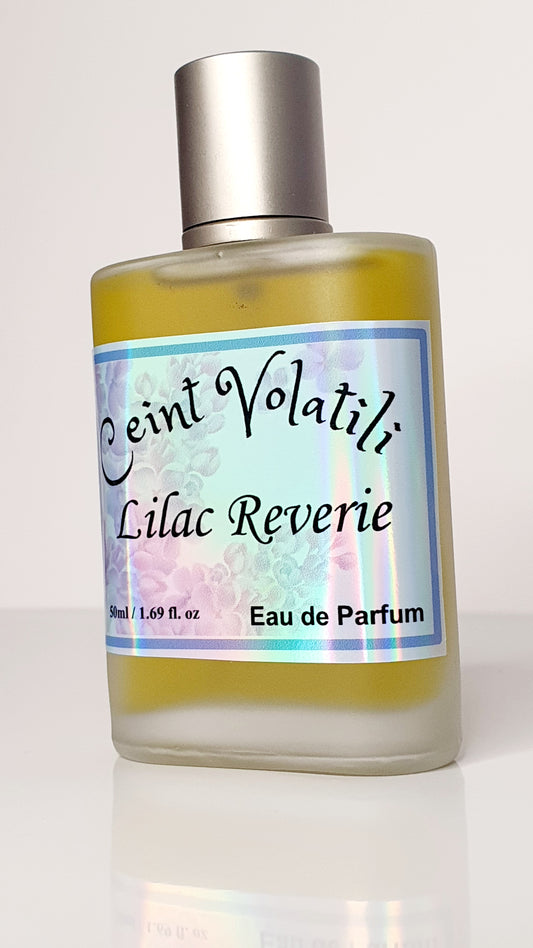 A clear bottle labeled 'Ceint Volatili Lilac Reverie' with a reflective, shiny label and a silver cap, containing a yellow-toned liquid, likely the perfume 'Lilac Riverie'.