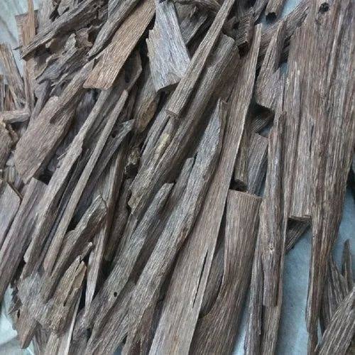 Natroil White Oud Oil bottle on dark background with aromatic agarwood pieces